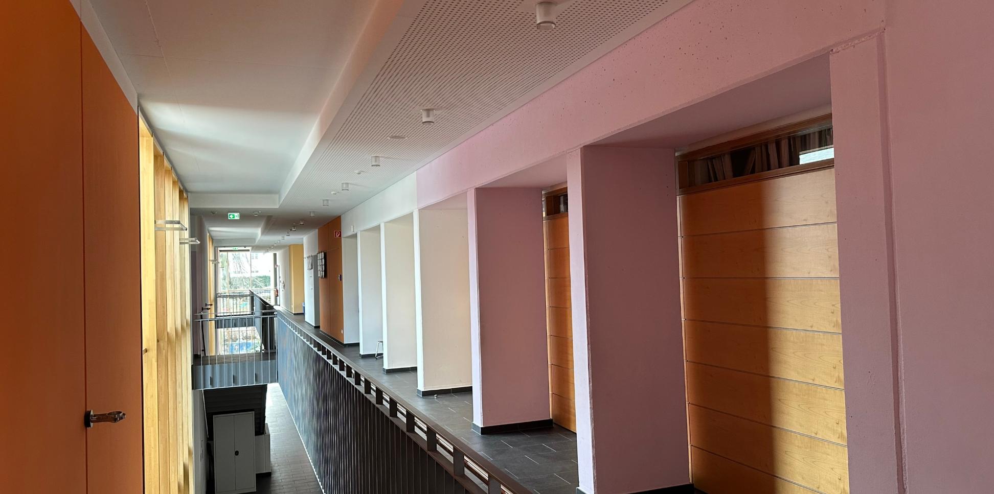 Man schaut durch den sonnenbelichteten Flur im ersten Stock der Grundschule am Dom.