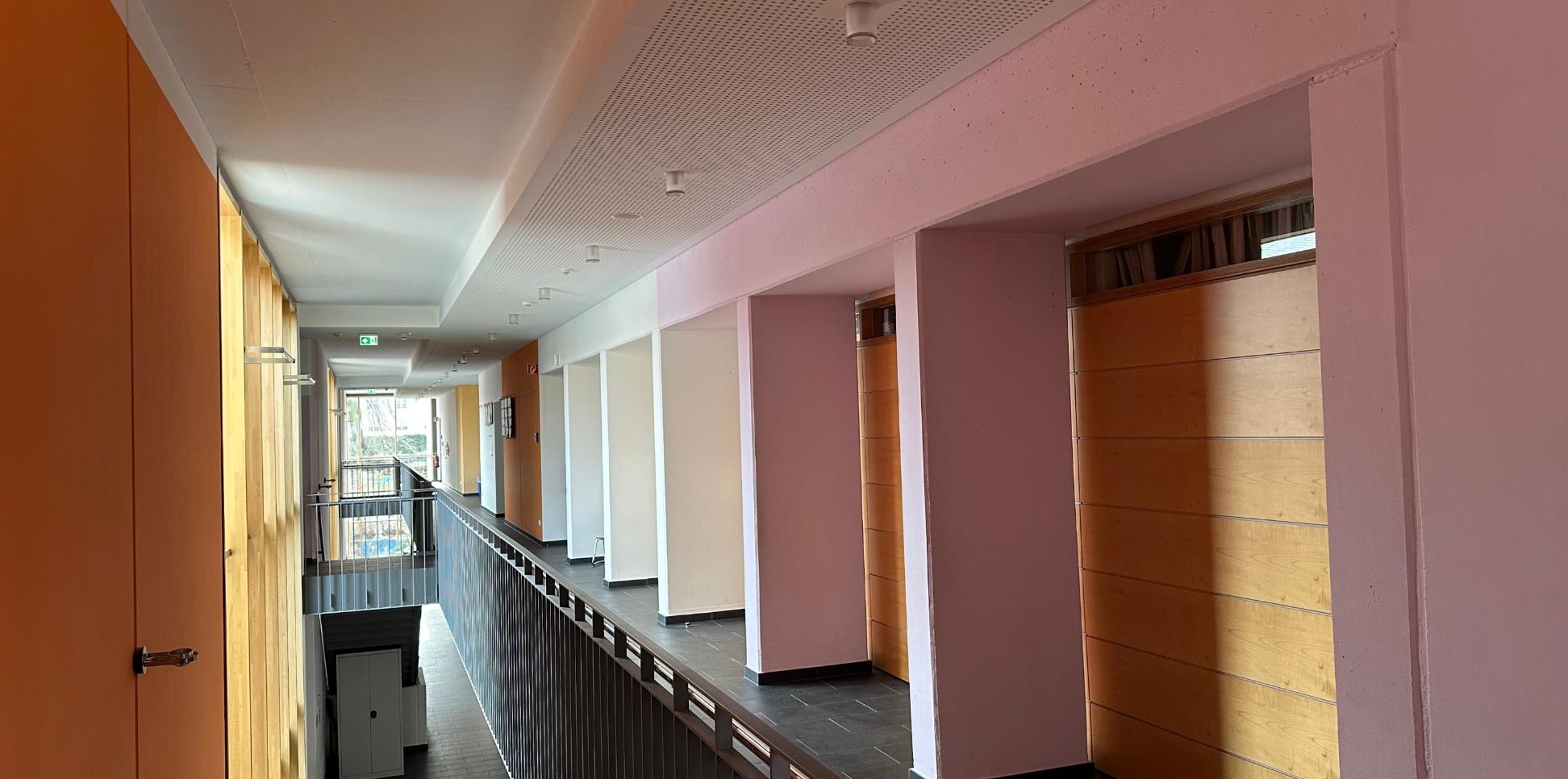 Man schaut durch den sonnenbelichteten Flur im ersten Stock der Grundschule am Dom.