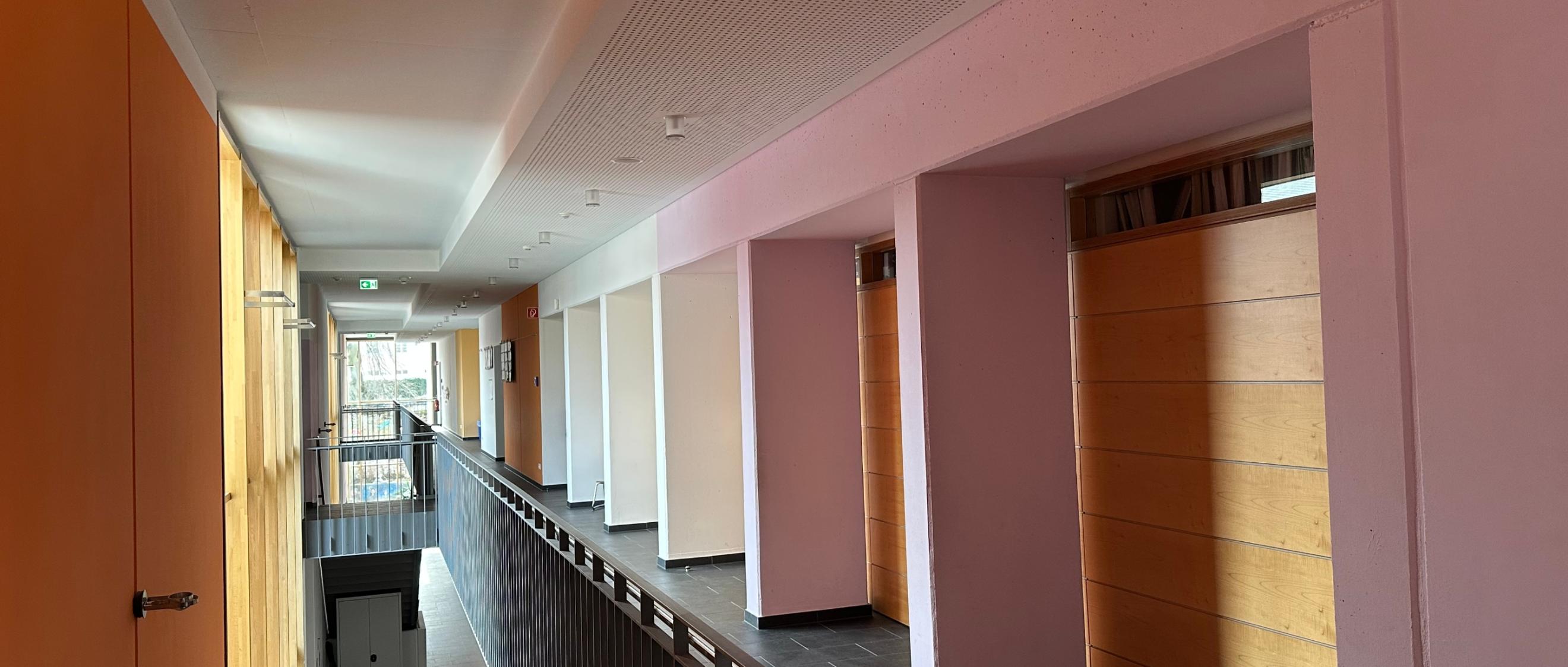 Man schaut durch den sonnenbelichteten Flur im ersten Stock der Grundschule am Dom.