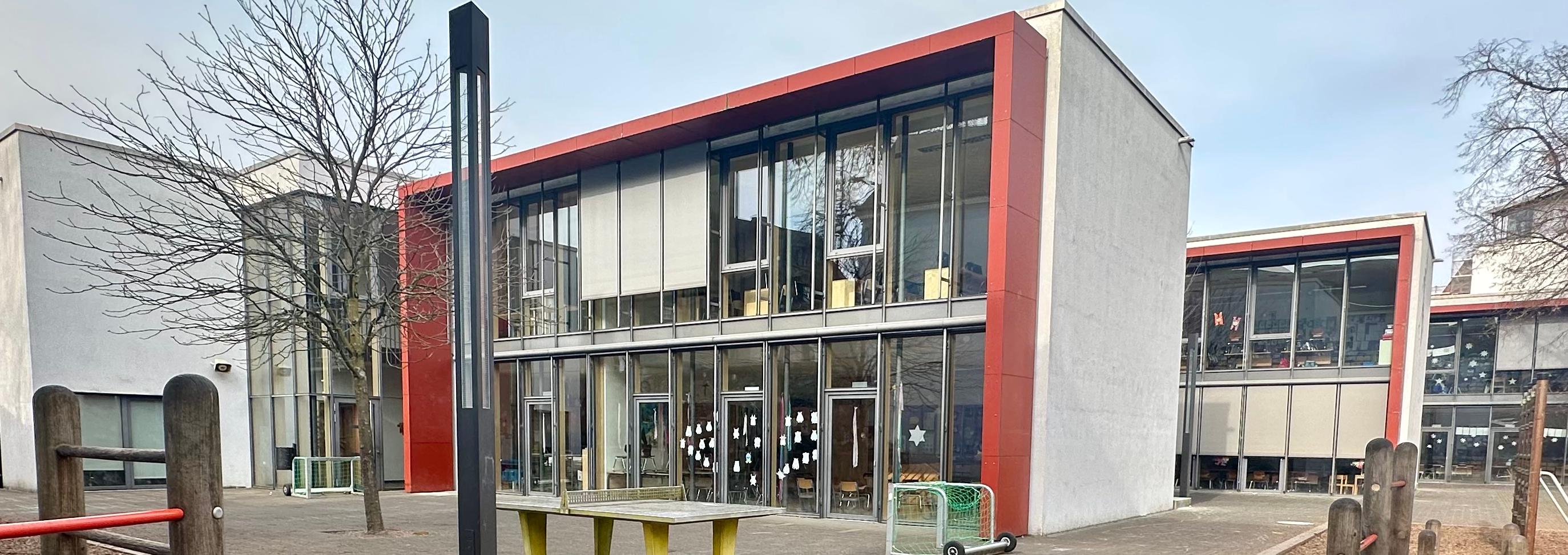 Man sieht - vom Schulhof aus - auf die drei großen Gebäudetrakte der Grundschule am Dom.