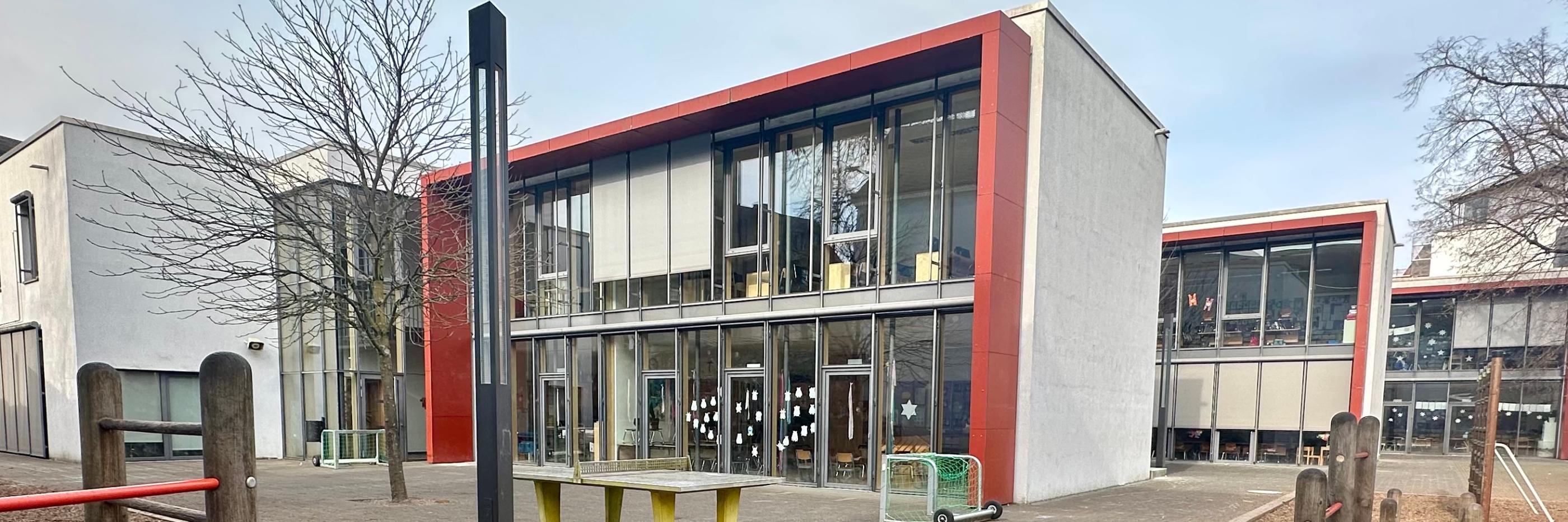 Man sieht - vom Schulhof aus - auf die drei großen Gebäudetrakte der Grundschule am Dom.