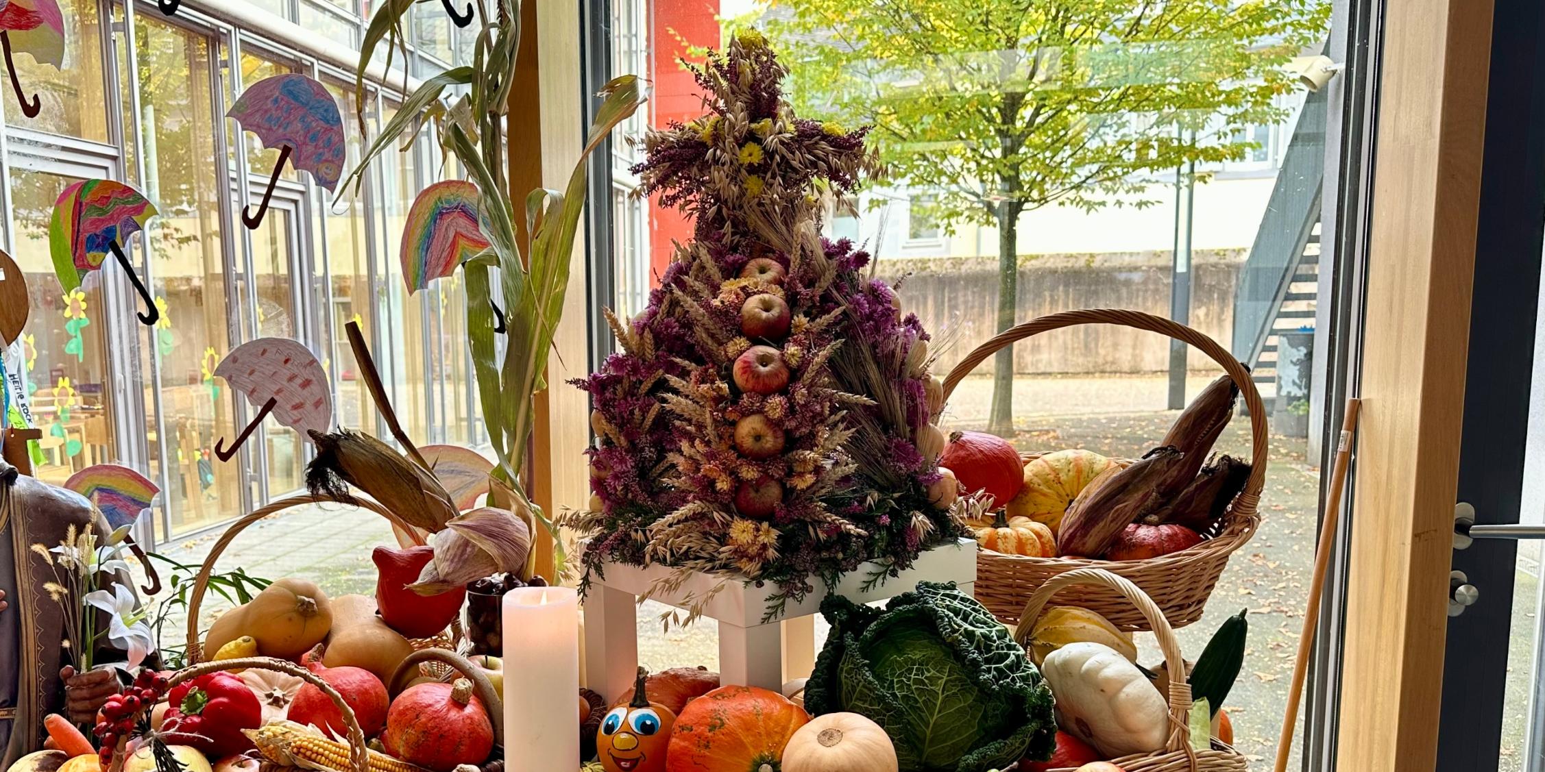 reich gedeckter Erntetisch mit Früchten und einer großen Erntekrone im Foyer der GS am Dom
