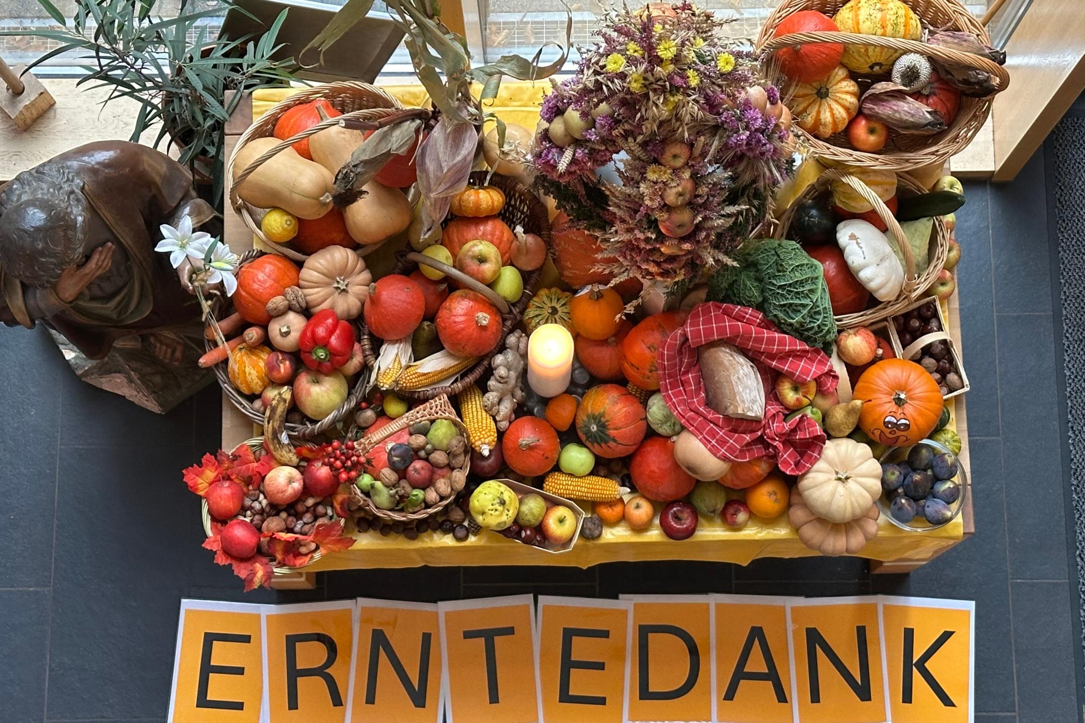 Blick von oben auf den reich gedeckten Erntedank-Tisch im Foyer der GS am Dom mit Schriftzug ERNTEDANK