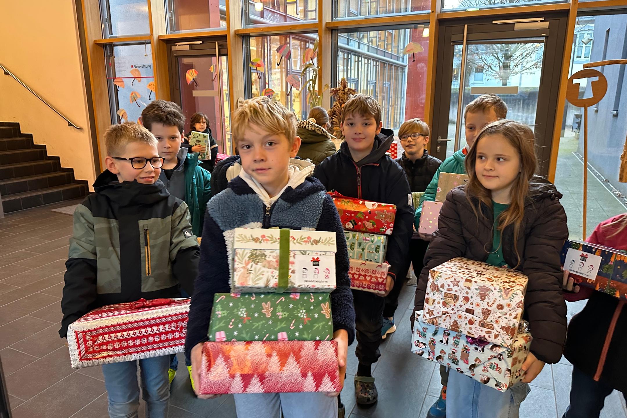 Kinder der GS am Dom bringen gespendete Geschenke zum Transporter
