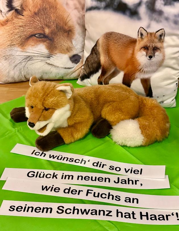 Fuchs-Plüschtier und Fuchs-Kissen hinter Spruch zum neuen Jahr auf Jahreszeitentisch GS am Dom