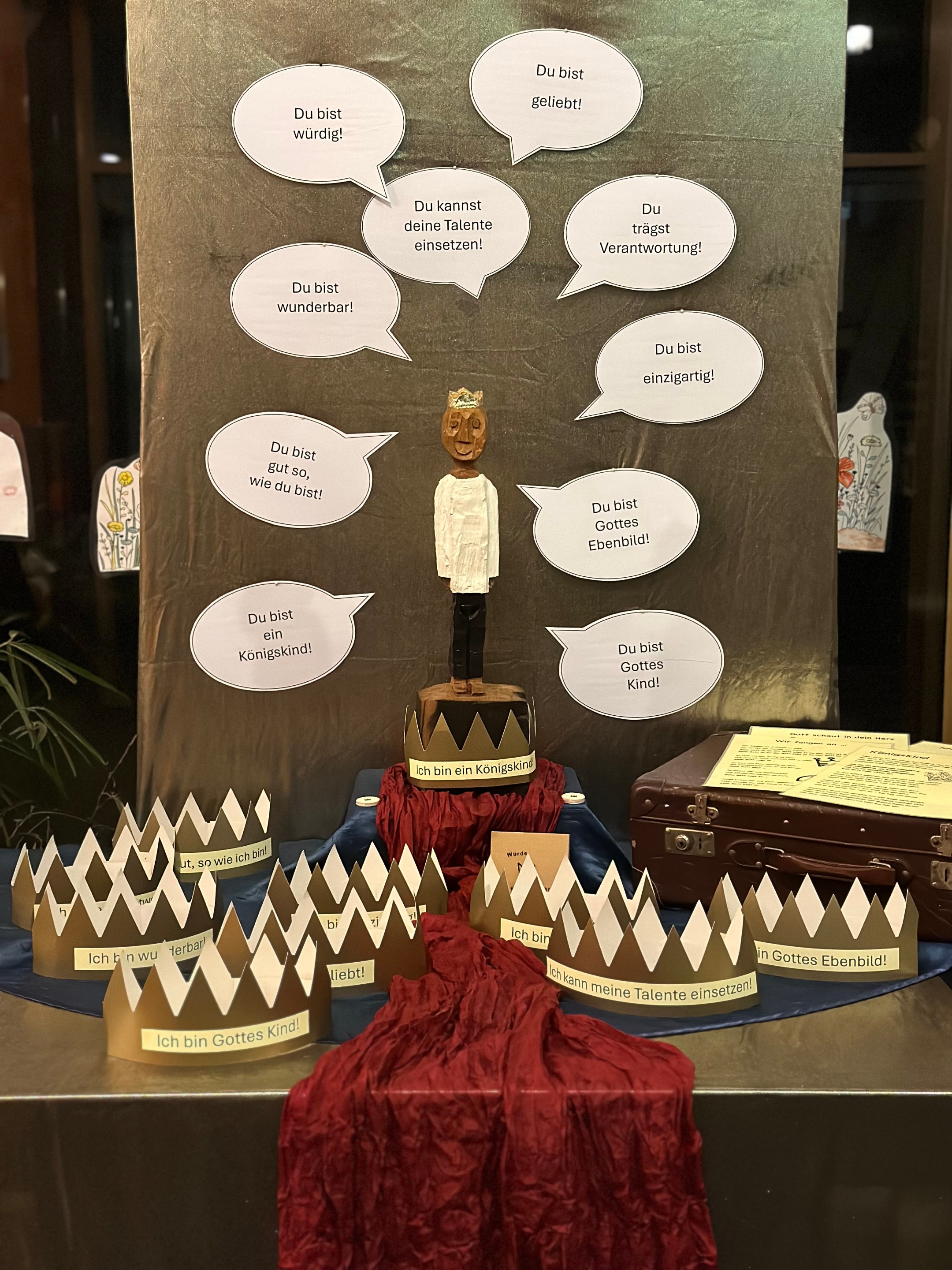 Die Holzfigur 'Der kleine König' steht auf dem königlich geschmückten Jahreszeitentisch der Grundschule am Dom