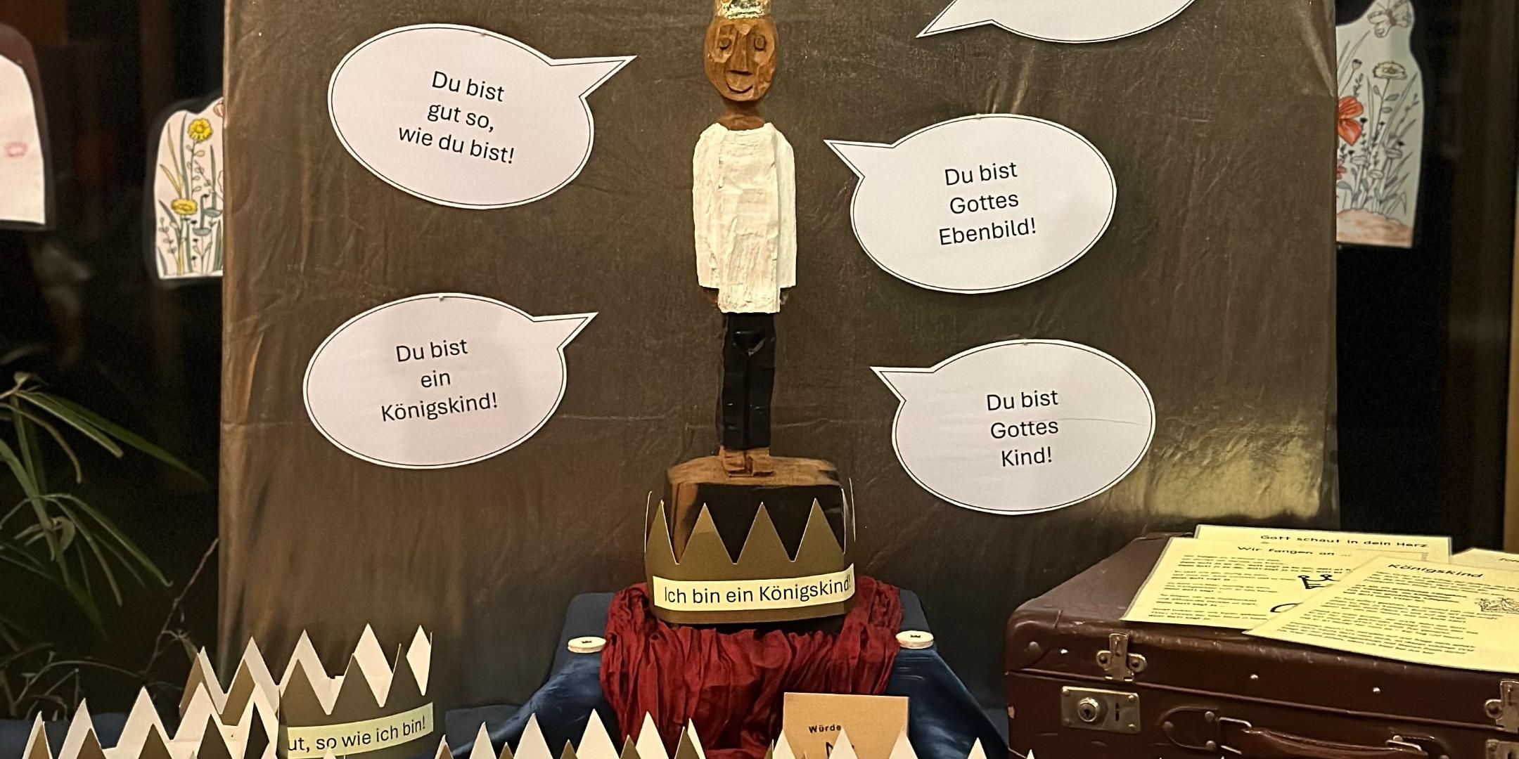 Die Holzfigur 'Der kleine König' steht auf dem königlich geschmückten Jahreszeitentisch der Grundschule am Dom